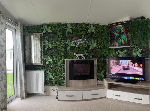 a living room with a wall covered in ivy at Skye Breaks in Sheerness