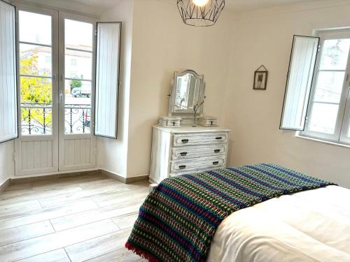 a bedroom with a bed and a dresser with a mirror at A Casa da Praça in Vila Viçosa