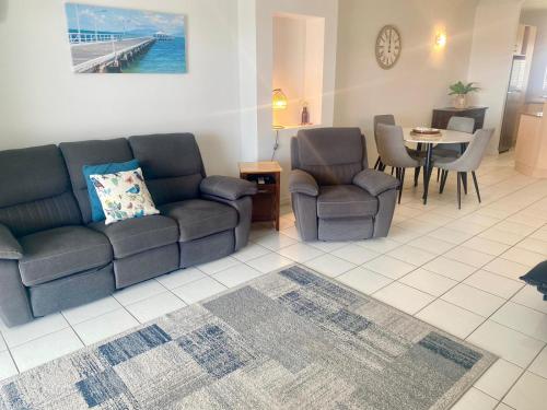 a living room with a couch and chairs and a table at Marina Views On Melton 107-3 Melton Terrace, Townsville in Townsville