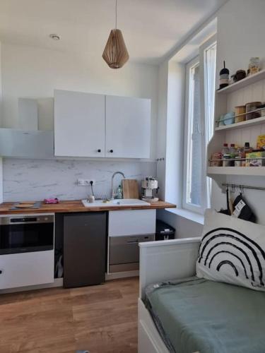 une cuisine avec des armoires blanches et un comptoir dans l'établissement Élégance au Bord de l'Eau, à Aiguebelette-le-Lac