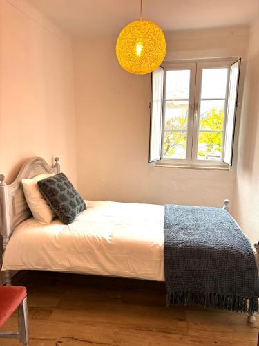 a bedroom with a bed and a window at A Casa da Praça in Vila Viçosa