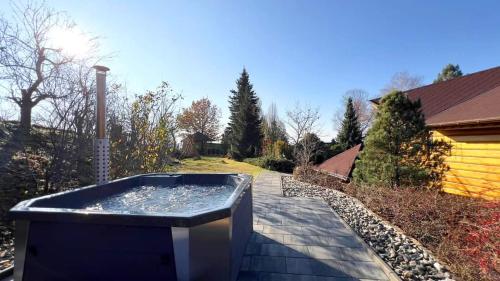 a hot tub sitting on a patio in a yard at Willa Chruślice-Basen sezon,Sauna in Nowy Sącz