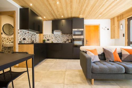 un salon avec un canapé et une cuisine dans l'établissement Contemporary 2 bed apartment in central Morzine, à Morzine