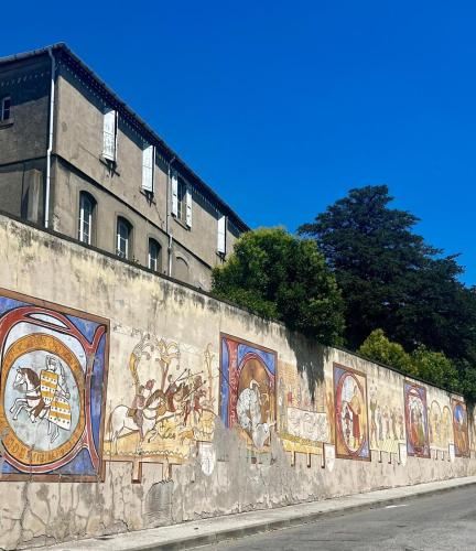 a wall with paintings on the side of it at Les Bellevue Cité Trivalle "3 Apartments, 1 with Terrace & Private Parking, Aircon, WiFi, 500m from Cité, free public car park 200m" in Carcassonne