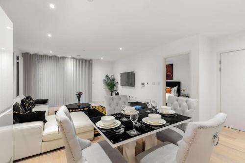 a dining room and living room with a table and chairs at Prime Home in London