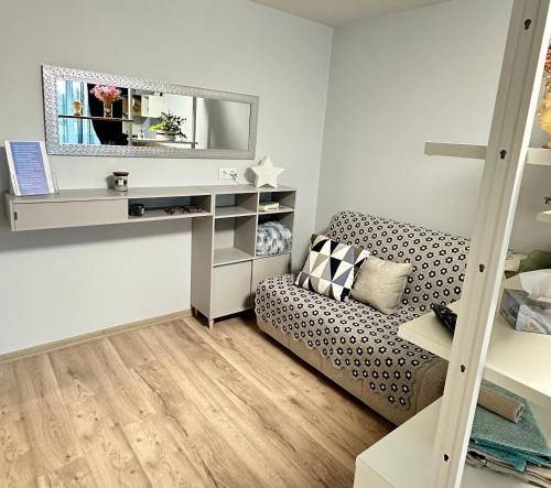a living room with a couch and a mirror at LIUxSAU apartmentai in Mažeikiai