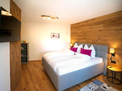 a bedroom with a large white bed with red pillows at ALPENGONDEL Suite - Charming Mountain Apartment with Balcony, presented by AlpenLuxus in Kramsach