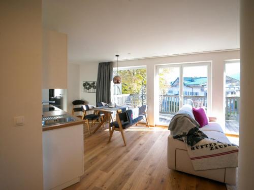 a kitchen and living room with a couch and a table at ALPENGONDEL Suite - Charming Mountain Apartment with Balcony, presented by AlpenLuxus in Kramsach