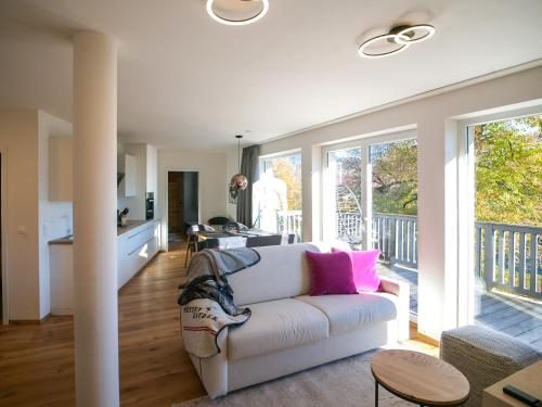 a living room with a white couch with pink pillows at ALPENGONDEL Suite - Charming Mountain Apartment with Balcony, presented by AlpenLuxus in Kramsach