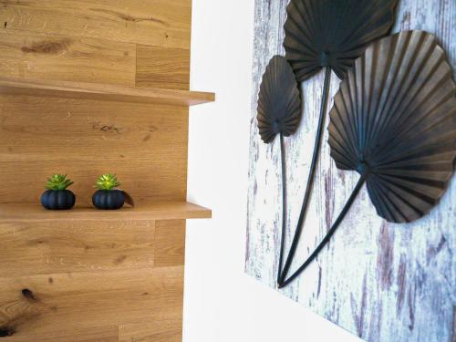 a couple of black plants on a wooden shelf at ALPENGONDEL Suite - Charming Mountain Apartment with Balcony, presented by AlpenLuxus in Kramsach