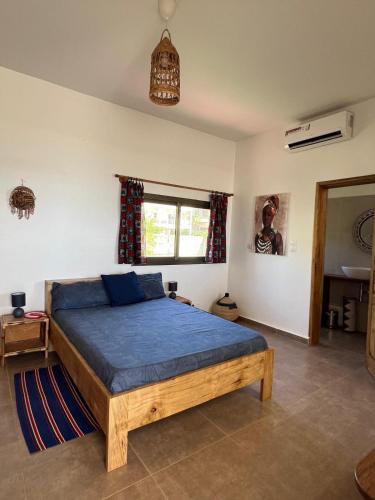 a bedroom with a bed with blue sheets and a window at Villa Vista in Toubab Dialaw
