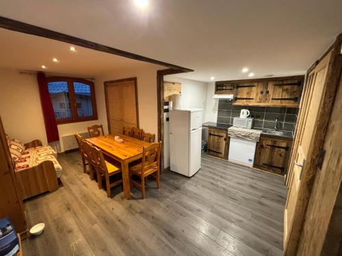 a kitchen and dining room with a wooden table and chairs at Chalet Alpina résidence Val Claret in Tignes