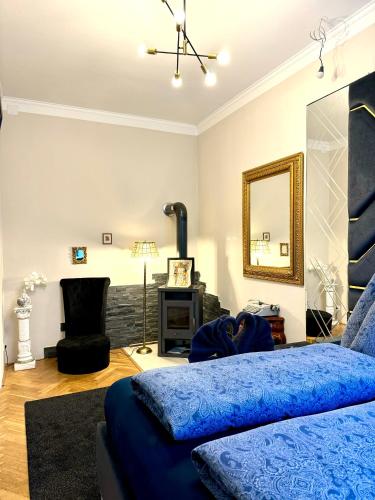 a bedroom with a blue bed and a fireplace at Belvedere Apartment in Vienna