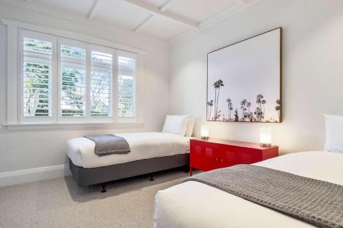 a bedroom with two beds and two windows at Luxury Central Villa with Spa Pool Prime Location in Auckland