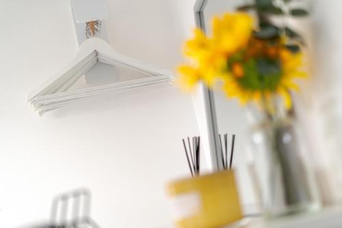 a mirror with a vase of flowers next to a vase of flowers at The Old Bike Cabin Flat 1 in Heapey
