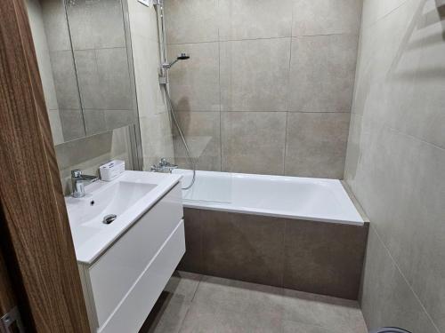a bathroom with a tub and a sink and a shower at 3 izbový byt in Prievidza