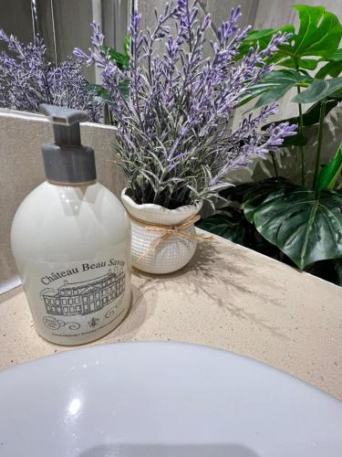 a bottle of soap sitting next to a sink with purple flowers at Villa Chianese in Naples