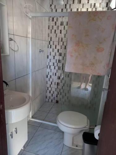 a bathroom with a shower and a toilet and a sink at Simplesmente aconchegante in Itapoa