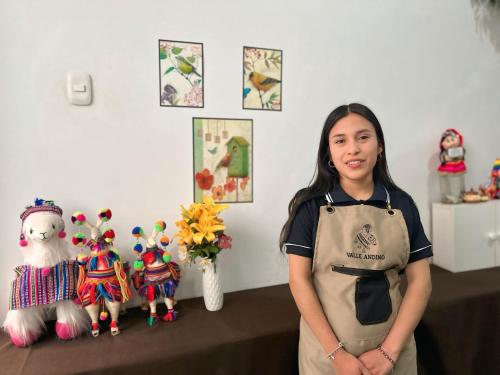 a woman standing in front of a table with stuffed animals at Hotel Valle Andino in Cusco