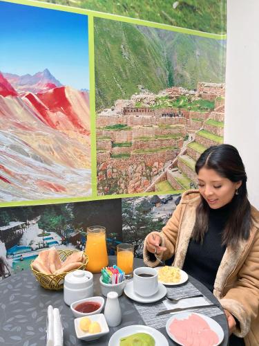 a woman sitting at a table with food at Hotel Valle Andino in Cusco