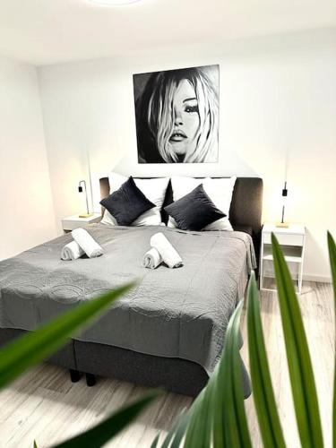 a bedroom with a bed with a painting on the wall at Highlife Apartment Bad Kreuznach ONE in Bad Kreuznach