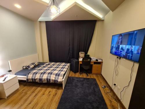 a bedroom with a bed and a flat screen tv at 2 spacious bedrooms apartment in Cairo
