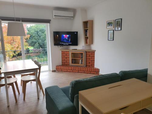 a living room with a couch and a table and a television at Casa da Conceição in Vila Real