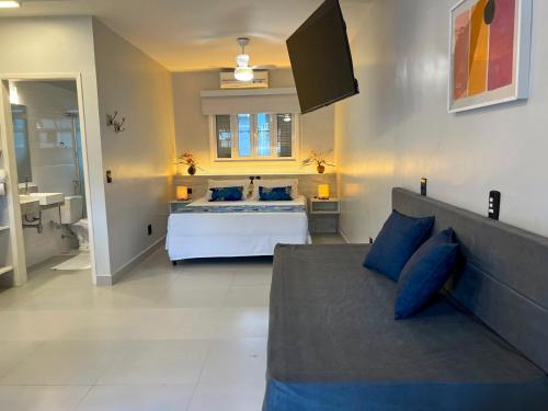 a large bedroom with a bed and a television at Pousada Camburioca in Camburi