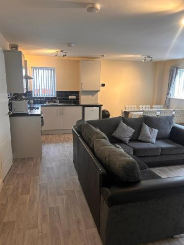 a living room with a couch and a kitchen at Easy Living Stays Burton on Trent in Burton upon Trent
