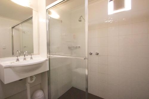 a bathroom with a shower and a sink and a toilet at Old Willyama Motor Inn in Broken Hill