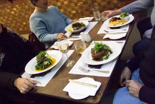 a group of people sitting at a table with plates of food at Old Willyama Motor Inn in Broken Hill