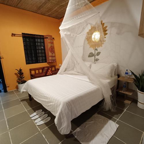 a bedroom with a bed with a white comforter at Madam Sokha Homesteading in Siem Reap