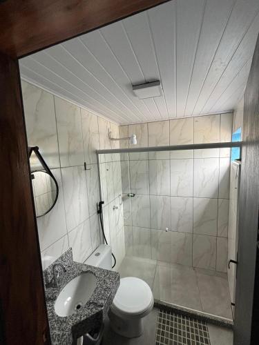 a bathroom with a shower and a toilet and a sink at Pousada Vista das Pedras in Pancas