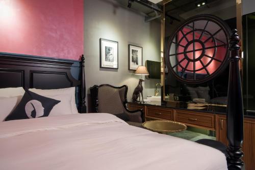 a bedroom with a bed and a desk with a mirror at Hotel The Designers Dongdaemun in Seoul