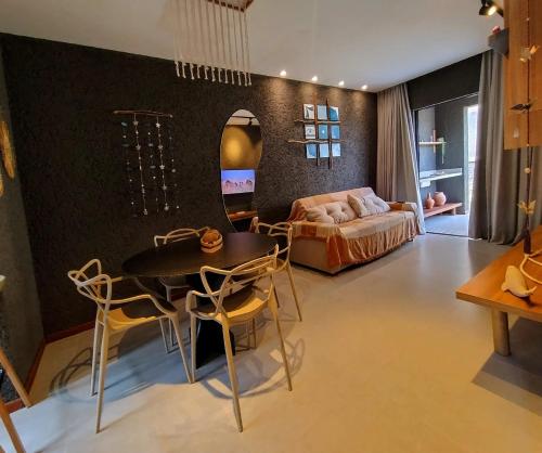 a living room with a table and a bed and a mirror at Patacho Porto Gamboa in Pôrto de Pedras
