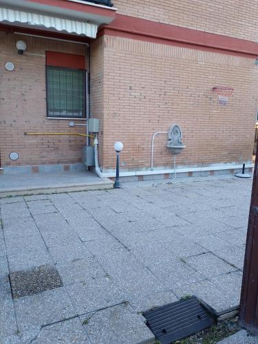 a brick building with a sidewalk in front of it at Stella Marina in Torvaianica