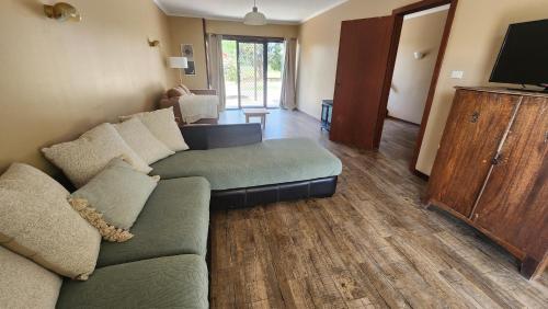 a living room with a couch and a flat screen tv at Bahwidgee Lodge - Riverside Retreat in Tumut