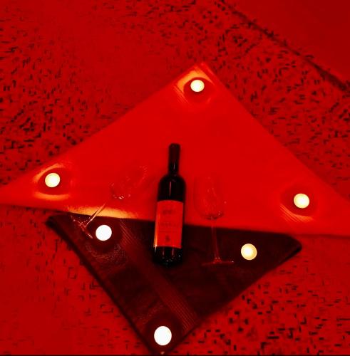a bottle of wine sitting on a table with two glasses at NelaLux in Podgradac
