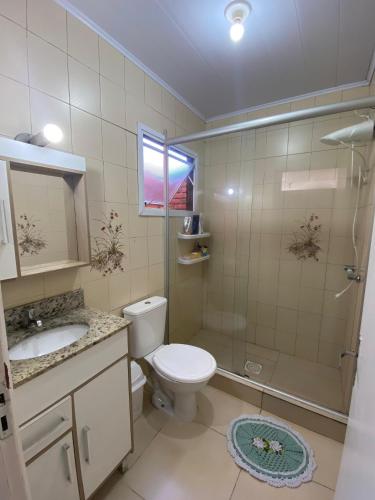 a bathroom with a toilet and a shower and a sink at Casa Grande 400m da praia do lado do centrinho in Imbé