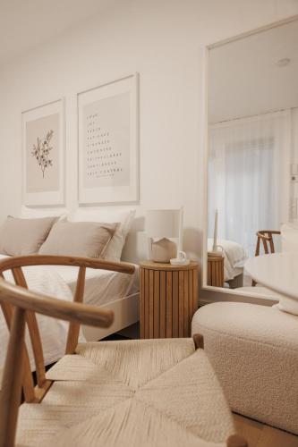 a white room with two beds and a chair at BOHO Loft - Augarten City Apartment, Terrace in Vienna