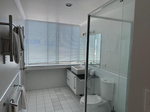 a bathroom with a glass shower and a toilet at Corporate Accommodation - Modern CBD Apartment in Hamilton