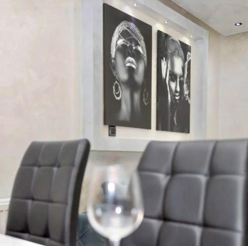 a dining room with a chair and two pictures on the wall at NelaLux in Podgradac