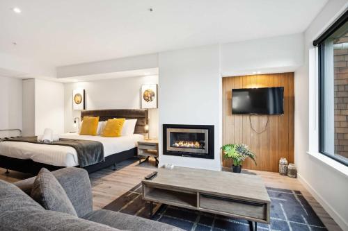 a hotel room with a bed and a fireplace at Rēhia at La residence du Parc in Queenstown