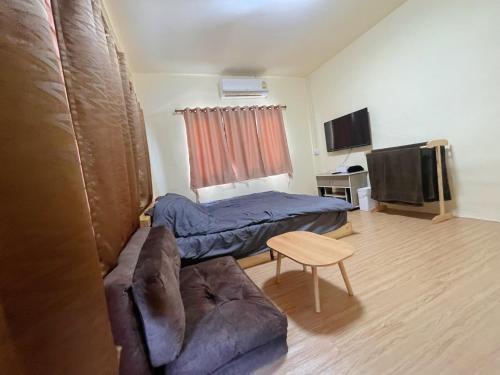a living room with a bed and a couch at Pitcha Home in Doi Saket