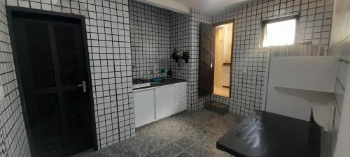 a bathroom with a black door and a sink at Arraial Beach Hostel in Arraial do Cabo