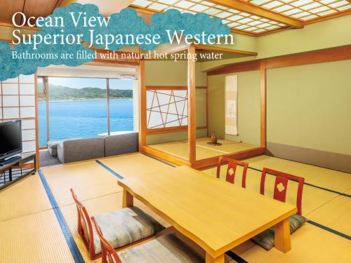 a room with a table and chairs and a tv at KAMENOI HOTEL Nachi Katsuura Kumano Kodo in Nachikatsuura