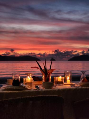 a table with candles on the beach at sunset at Seda Lio in El Nido