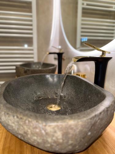 a bathroom sink with water coming out of it at Appartement neuf haut standing - jacuzzi à Strasbourg in Schiltigheim