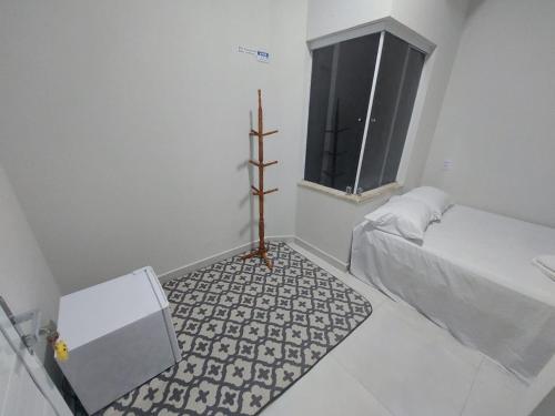 a small white room with a bed and a window at Pousada Luz do Sol in Piranhas