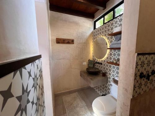 a bathroom with a toilet and a sink and a mirror at Ca Nikte Cabañas in El Cuyo
